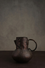Vintage brass Jug Vase Mug with handle. Still life with old cracked jug and copy space.