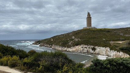 Fototapeta na wymiar panoramic view of the tower of hercules in la acoruña, spain. dark stormy sky and surrounding nature. You can see the surrounding beach