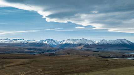 Agricultural fields and rural  farming country on the shores of Lake Tekapo under dramatic cloudscape