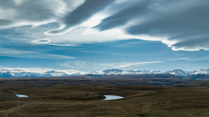 Agricultural fields and rural  farming country on the shores of Lake Tekapo under dramatic cloudscape