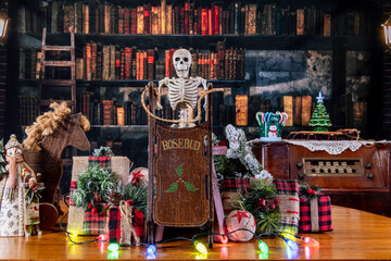 Christmas decorations with skeleton holding rosebud sled in old library