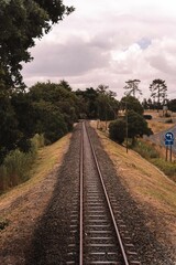 Fototapeta na wymiar Vertical shot of an old train track between trees