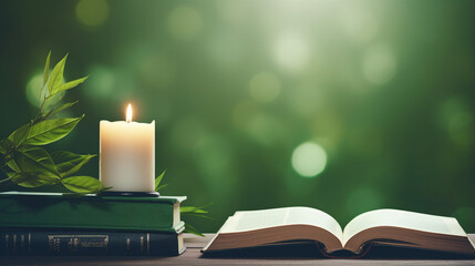 Open book with candle and leaves, serene green backdrop