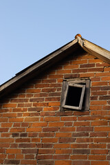 Old brick house with a broken window