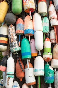 Various colored old Maine lobster trap buoys hanging. Colorful background.