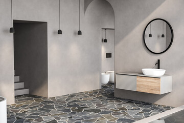 Stylish gray bathroom interior with pavement floor, toilet, big bathtub and white sink with oval...