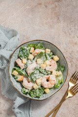 Fresh caesar salad on bowl with parmesan cheese and shrimps