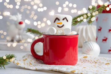 Red mug with hot chocolate with melted marshmallow snowman