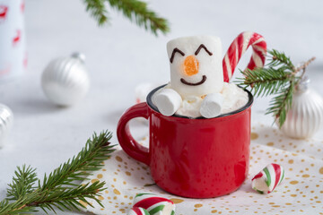 Red mug with hot chocolate with melted marshmallow snowman