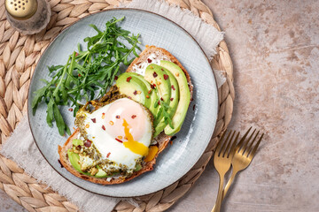 Avocado egg sandwich. Healthy light breakfast concept. Whole grain toasts with avocado and fried pesto eggs