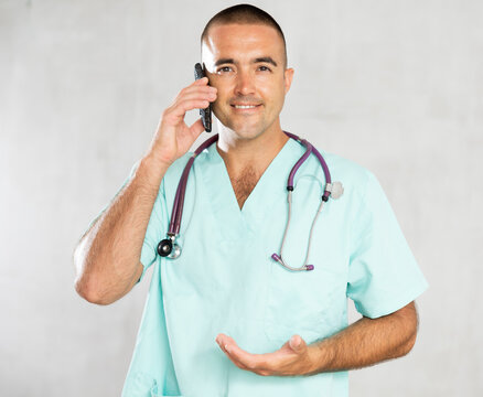 Engaged in direct telephonic conversation, male physician imparts medical insights remotely.