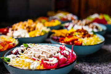 Closeup shot of bowls with different vegetables and mayonnaise