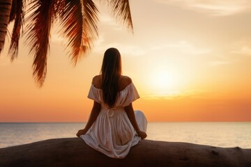 Fototapeta na wymiar Lovely graceful lady sit by beach at sunset with beautiful seascape. Summer tropical vacation concept.