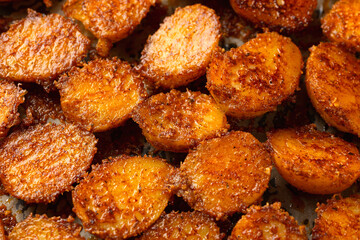 Parmesan crusted baby new potatoes on a baking tray