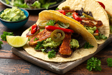 Fried halloumi fajitas with pan roasted onions and bell peppers, avocado guacamole and pickled jalapeno peppers