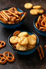 Salty snacks crackers, pretzels in bowls. Party food.