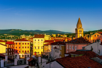 amazing evening town with church, tower with bell , yellow houses and beautiful hills with nice...