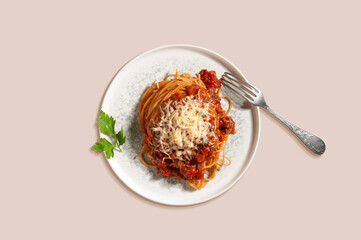 Spaghetti with cherry tomatoes, sauce, herbs and cheese..Isolated plate with hot, fresh pasta on beige background