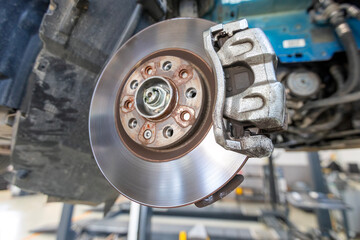View of brake pads, wheel hub, rotor (disk) and caliper in car. Brake pads are a component of disc...