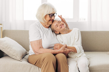 Home love grandmother couch sofa happy family child hugging girl granddaughter