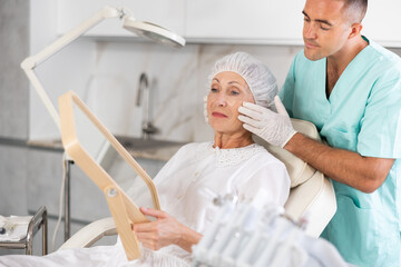 Having concluded treatment, male physician reveals results to satisfied female patient.