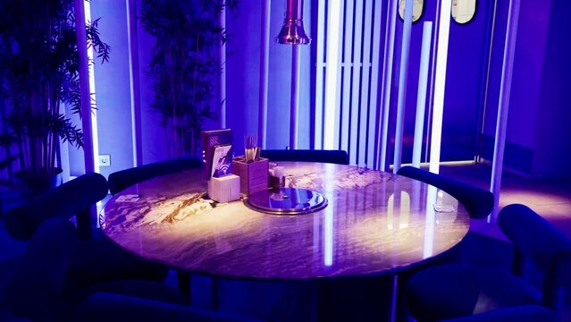 the interior of a Korean institution in neon color in a restaurant tables a bar counter