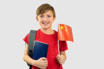 happy child learning a foreign language, a boy holds a china flag 