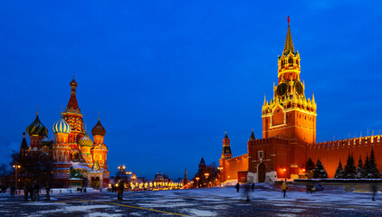 View of illuminated Spasskaya Tower and Saint Basils Cathedral on Red Square in Moscow on winter...