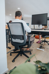 A diverse team of confident business people analyzing reports, using technology, and working together in a creative office for future success.