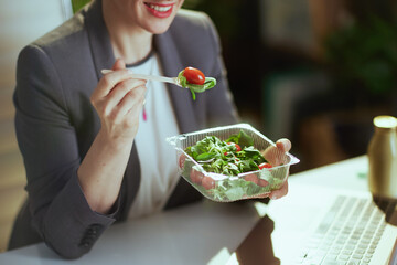 happy accountant woman in green office eating salad