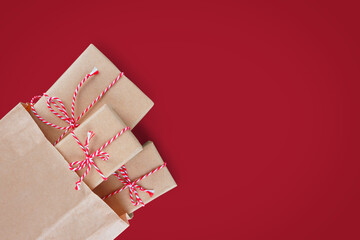 Christmas gift boxes wrapped in craft paper with striped red and white baker's twine in brown...