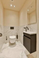 a modern bathroom with marble flooring and white walls, along with a black vanity in the room is illuminated by recessed lights