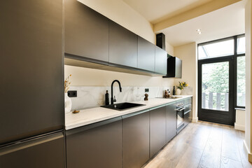 a modern kitchen with black cabinets and white counter tops on the island in this small space is...