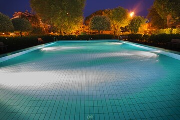 Closeup shot of a swimming pool in the park at dark night