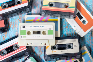 Top view of several music cassettes stacked on wood with pickled paint.