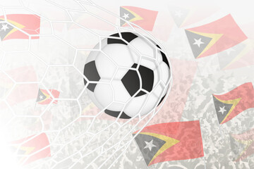 National Football team of East Timor scored goal. Ball in goal net, while football supporters are waving the East Timor flag in the background.
