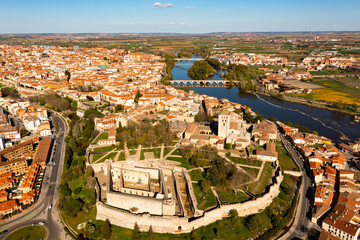 Picturesque aerial view of Zamora city on banks of Duero river overlooking terracotta tiled roofs of residential buildings, medieval walled castle and cathedral on spring day, Spain - obrazy, fototapety, plakaty