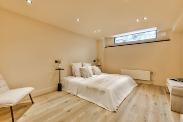 Fototapeta na wymiar a bedroom with wood flooring and white bedding in the middle of the room, there is a large window