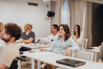 Group of businesspeople gathered in a seminar meeting in a white classroom, conference meeting