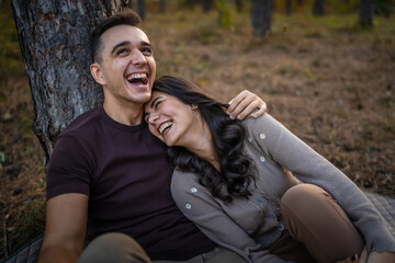 Fototapeta premium Man and woman young adult couple in love sit in nature