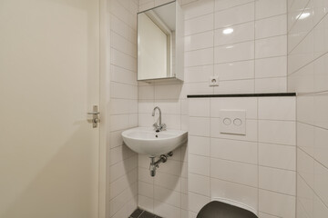 a small bathroom with a sink and mirror on the wall next to an open door that leads to a walk - in...