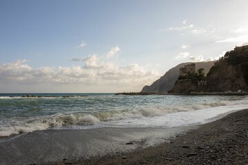 Empty beach on dramatic coast with a rocky headland