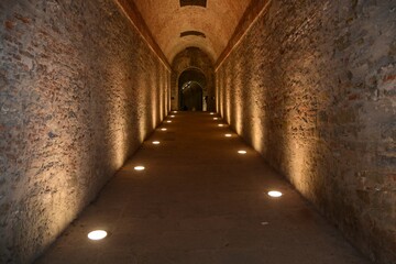 Obraz premium Long dark corridor illuminated with lights on the ground