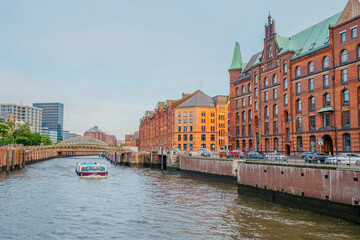 Hamburg, Germany - 25 October 2023: View on the brick  buildings and a touristic boat on a canal in Kehrwieder in Hamburg.