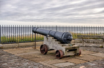St Andrews, Scotland - September 22, 2023: A historic cannon along the shoreline pathway of St Andrews in Scotland at sunrise
