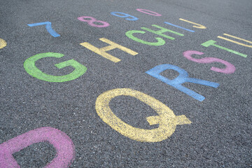 the alphabet and numbers are drawn with color paint on a children's playground designed creative...