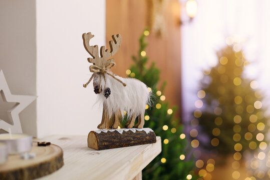 Christmas composition with beautiful decoration, christmas tree and wooden deer, horse, stars and other accessories in modern home.