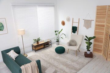 Stylish room interior with comfortable armchair, sofa and houseplants, above view