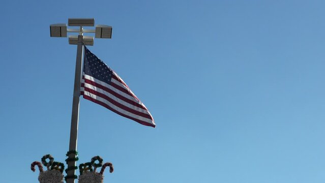 USA flag over Christmas decoration on blue sky background.