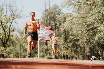 Sprinting with Parachute. Outdoor Cardio for Strong Athletes Enjoying Sunny Summertime Workout.